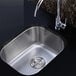 A Ruvati stainless steel sink with a faucet and drain.