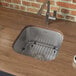 A Ruvati stainless steel undermount sink with a drain, a wine glass, and a cup of coffee.