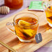 A glass cup of Stash Decaf Premium Green Tea with a tea bag in it.