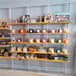 A white wall-mounted retail clothing display with shelves holding different items.