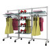 A white Udizine mobile retail clothing display stand with clothes on hangers and shoes on shelves.