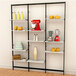 A black Udizine wall-mounted retail clothing display with shelves holding a variety of objects.