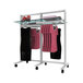 A white Udizine mobile 2-section retail clothing display stand with faceouts and hanging rails holding dresses and shoes.