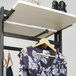 A black UDIZINE round tubing faceout holding a black and white floral shirt on a retail clothing rack.