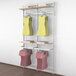 A white Udizine retail clothing display rack with dresses and shirts hanging on it.