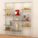 A white Udizine wall-mounted retail clothing display with glass shelves holding various items.