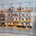 A white wall-mounted retail clothing display with shelves holding a variety of items.