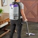 A woman using a ProTeam GoFit 3 cordless backpack vacuum to clean the floor.
