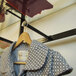 A black Udizine clothing display rack with two faceouts holding a coat.