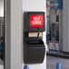 A black Lavex wall-mounted windshield wash station with a paper towel dispenser and squeegee.