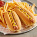 Two hot dogs with mustard on Martin's Famous Top-Sliced Potato Rolls and french fries.