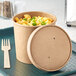 A Choice kraft paper food container with macaroni and cheese inside and a vented paper lid on a table.