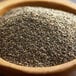 A bowl of Regal ground black pepper on a wooden table.