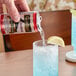 A hand pouring Goslings Finest Tropical Tonic Water into a glass.