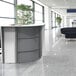 A white Correll curved corner reception desk with a tree in the background.