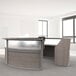 A Correll curved ash laminate reception desk with a glass top.