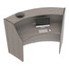 A Correll curved reception counter with a computer and keyboard on it.