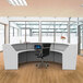 A white Correll curved U-shape reception counter with a black chair and a computer.