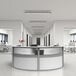 A white U-shaped curved reception desk with a plant on it.
