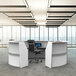 A white curved U-shaped reception desk with a chair in an office.