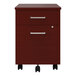 A Correll steel mobile pedestal filing cabinet with cherry laminate drawers and black wheels.