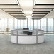 A white Correll curved U-shape reception desk with a chair in front of it.
