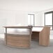 A Correll curved walnut laminate reception desk with a glass panel.