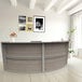A Correll curved reception counter with an ash wood top.