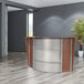 A Correll cherry laminate curved reception desk with a see-through panel.