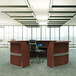 A cherry laminate curved reception desk with a black chair.