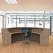 A wooden Correll reception desk with a computer on it.