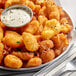 A plate of September Farms Breaded Cheese Curds with a bowl of white sauce and a fork.