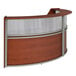 A Correll cherry laminate reception desk with curved wood panels and a see-through top panel.