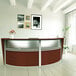 A cherry laminate Correll reception desk with a curved top and see-through panel.