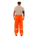 A person wearing Tingley Hi-Vis orange rain overalls.