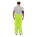 A man wearing Tingley hi-vis lime yellow rain overalls.