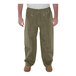 A person wearing Tingley olive drab green Magnaprene nylon pants.