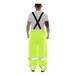 A man wearing Tingley hi-vis lime yellow overalls with black straps.