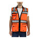 An orange Tingley safety vest with reflective stripes and an X on the back worn by a man.