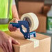 A person using Lavex masking tape to seal a box.