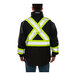 A man wearing a Tingley black jacket with reflective accents and an X-back vest.