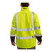 A person wearing a Tingley lime yellow and charcoal gray soft shell jacket.