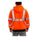 A person wearing a Tingley hi-vis orange zip-up sweatshirt with reflective stripes.