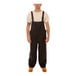 A man wearing Tingley black overalls.