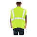 A person wearing a Tingley Hi-Vis lime yellow flame-resistant safety vest.