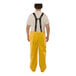 A man wearing yellow Tingley rain overalls.