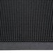 A close-up of a black rubber Cactus Mat with holes in it.