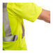 A man wearing a Tingley lime green short sleeve safety shirt pointing to his hand.