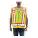 A man wearing a Tingley hi-vis yellow safety vest with X-back reflective tape.