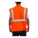 A man wearing a Tingley hi-vis orange safety vest with reflective stripes.